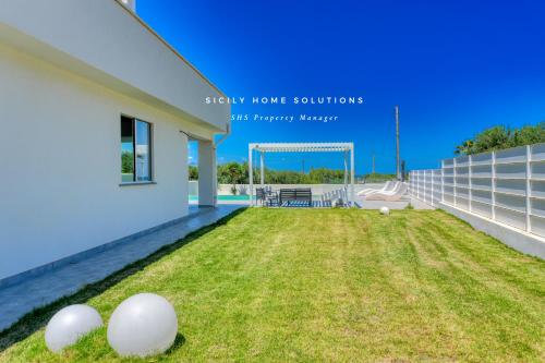 a house with a yard with white balls on it at Villa Stella con piscina privata 500 mt dal mare By Sicily Home Solutions in Trappeto