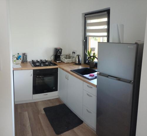 a kitchen with white cabinets and a refrigerator at Noclegi u Nikoli in Wola Wereszczyńska