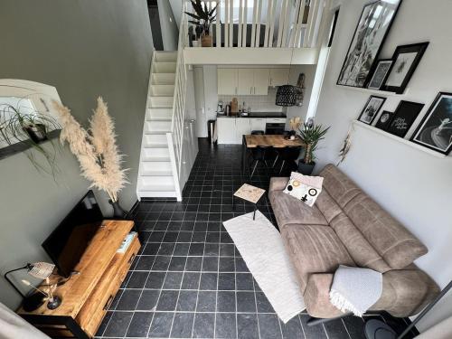 a living room with a couch and a staircase at Vorstelijk verblijf Alkmaar in Alkmaar