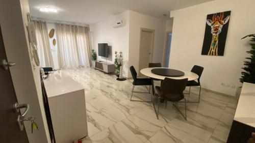 a living room with a table and chairs in a room at Appartement Ornella in Azuretti