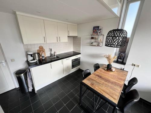 a kitchen with a wooden table and a counter top at Vorstelijk verblijf Alkmaar in Alkmaar