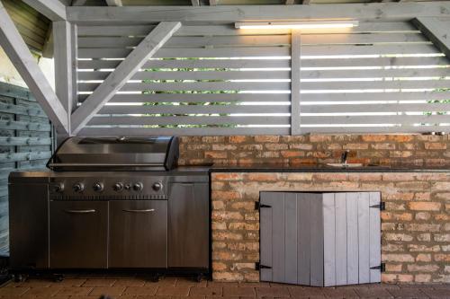a kitchen with a stove and a brick wall at Anna Vendégház in Visegrád