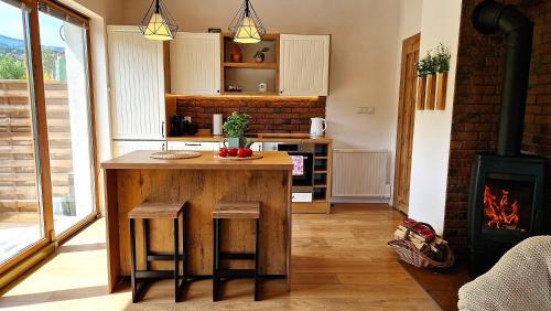 a kitchen with a wooden table and a stove at Widokowo - Domki z widokiem na Śnieżkę z Jacuzzi i Sauną in Karpacz