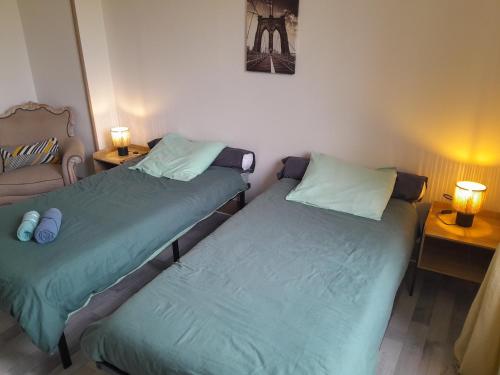 two beds sitting next to each other in a room at Maison standing vacances professionnel in Givet