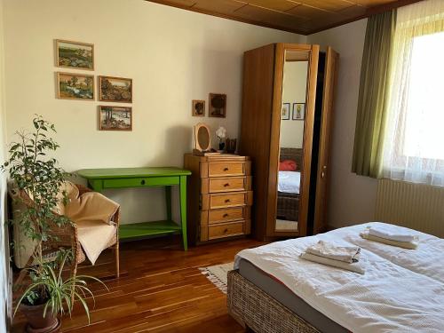 a bedroom with a bed and a green desk at Appartement zum Grenzstein in Rattersdorf