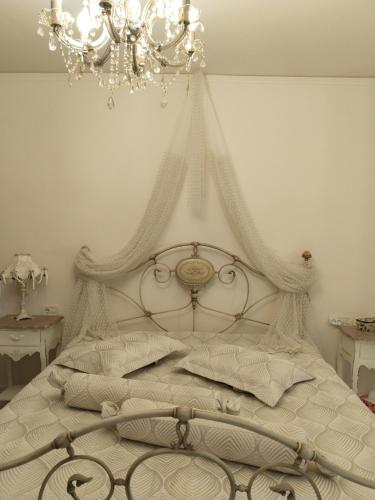 a bedroom with a white bed with a chandelier at Villa Kokalis Resort hotel in Gouves