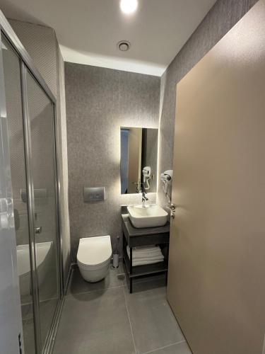 a bathroom with a toilet and a sink and a shower at Boss Otel Kahramankazan in Kışlaköy