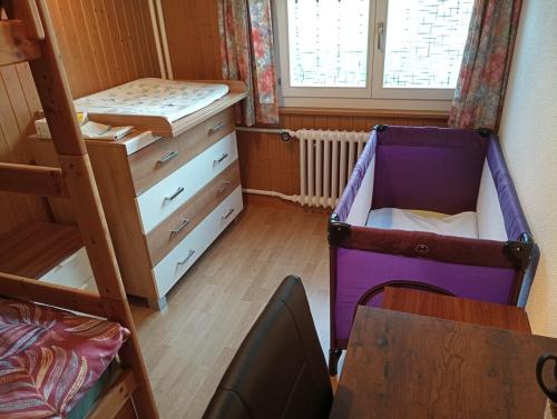 a bedroom with a bed and a dresser and a crib at 3,5 Zimmer Parterre Wohnung in Alpnach