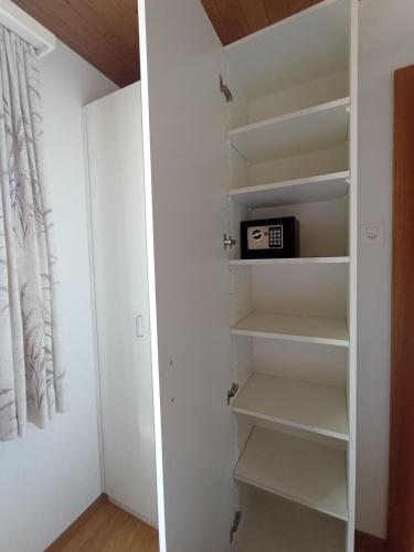 a walk in closet with white walls and white shelves at 3,5 Zimmer Parterre Wohnung in Alpnach