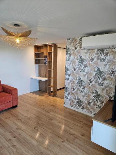 - un salon avec un canapé rouge et un mur dans l'établissement Bluemaya à La Grande Motte, à La Grande Motte