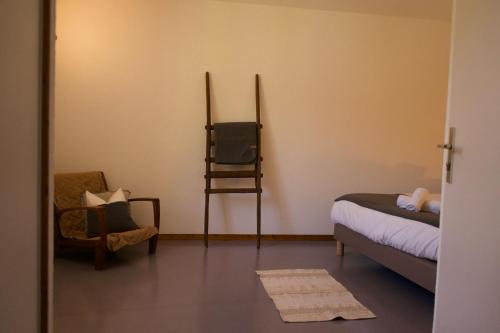 a room with a bed and a chair and a mirror at Auberge du Savel in Clavans-en-Haut-Oisans