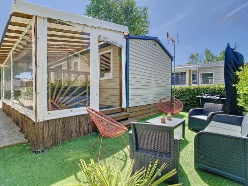 un grand bâtiment avec des chaises et une table dans l'établissement Mobil-home JA 51 à Vias - La Carabasse - Camping Siblu avec piscine, à Vias