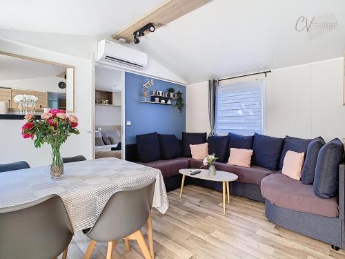 un salon avec un canapé et une table dans l'établissement Mobil-home JA 51 à Vias - La Carabasse - Camping Siblu avec piscine, à Vias