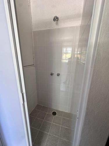 a shower stall with a tiled floor and white walls at Casa Artemisa hostal in Guadalajara