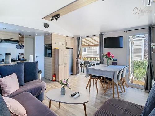 un salon avec un canapé et une table dans l'établissement Mobil-home JA 51 à Vias - La Carabasse - Camping Siblu avec piscine, à Vias