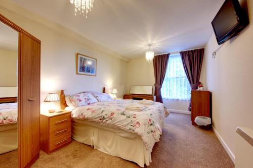una camera da letto con un letto e una televisione di Upcott Cottage a Barnstaple