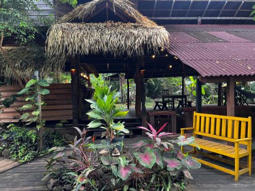 a wooden bench and a hut with some plants at TerrAmor Ecoliving in Alter do Chao