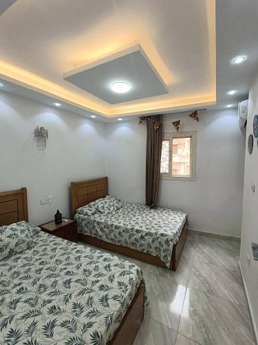 ein Schlafzimmer mit zwei Betten und einem Fenster in der Unterkunft العالمين لالعاب المائيه in El-Alamein