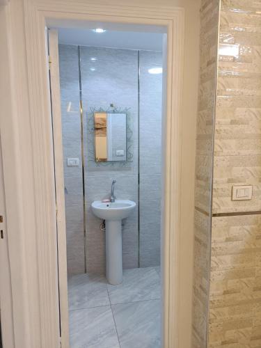 ein Badezimmer mit Waschbecken und Glasdusche in der Unterkunft العالمين لالعاب المائيه in El-Alamein