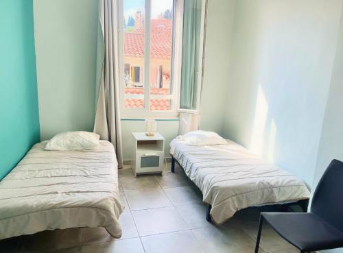 deux lits dans une chambre avec une fenêtre dans l'établissement La Maison de Rose, à Cassis