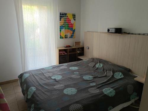 une chambre avec un lit avec une couverture dessus dans l'établissement Résidence les Parasols d'Argens, à Roquebrune-sur Argens