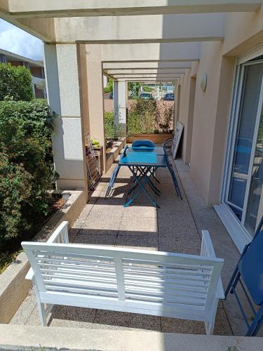 une terrasse avec une table bleue et un banc dans l'établissement Résidence les Parasols d'Argens, à Roquebrune-sur Argens