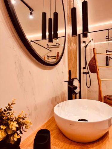 a bathroom with a large white sink and a mirror at Domki Dwa jelonki - balia z jacuzzi i sauna in Wisła