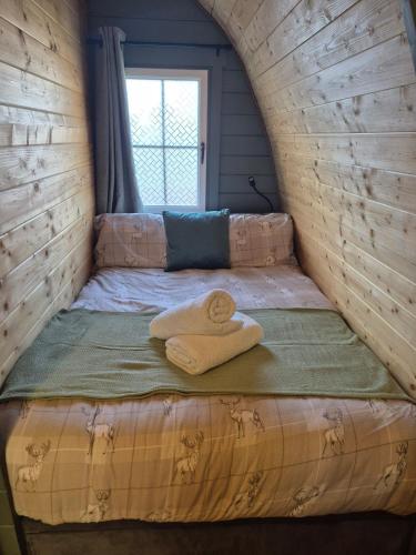 a bed with two towels on it in a room at Little Abrach Pod in Inverlochy