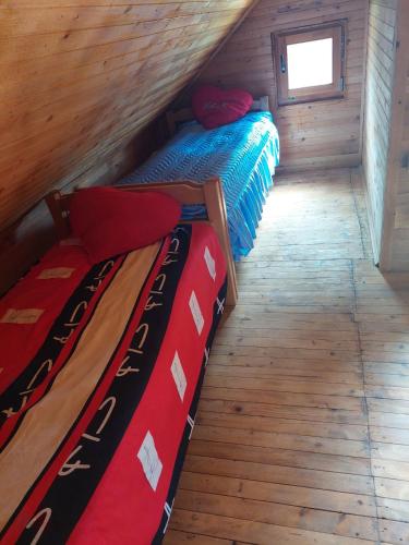 two beds in a small room with wood floors at Drinska Ljepotica Ljubovija in Bukorovac