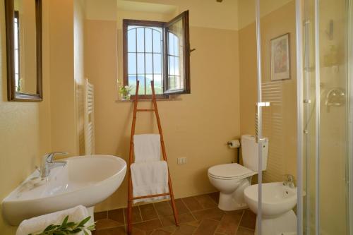 a bathroom with a sink and a toilet and a mirror at Locanda Le Giunche in Guardistallo