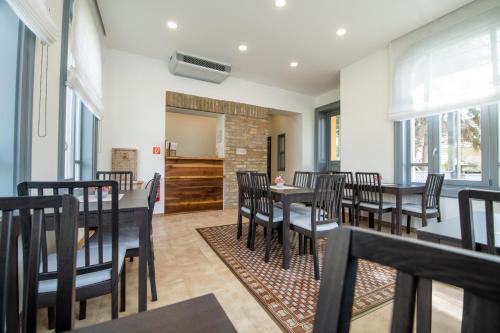 a dining room with tables and chairs and windows at Anna Vendégház in Visegrád