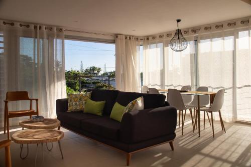 a living room with a black couch and a table at Mont Choisy 2BR Private Rooftop and Plunge Pool in Mont Choisy