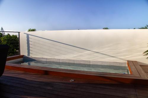 a glass pool on a deck with a white wall at Mont Choisy 2BR Private Rooftop and Plunge Pool in Mont Choisy