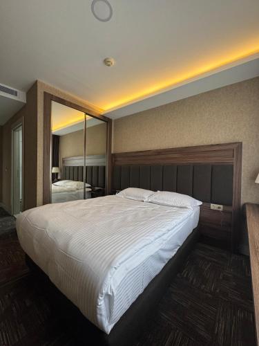 a bedroom with a large bed with a large mirror at Boss Otel Kahramankazan in Kışlaköy