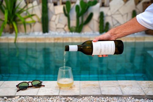 ギリ・トラワンガンにあるIsla Villas - Private Boutique Villasのグラスにワインを注ぐ者
