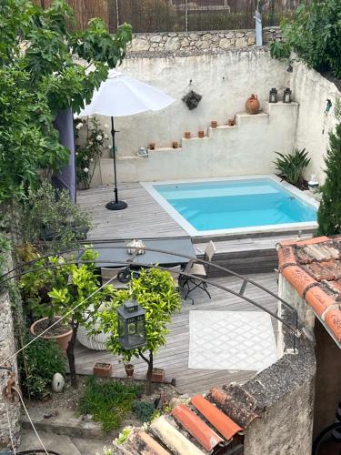 - une piscine avec un parasol sur une terrasse en bois dans l'établissement Charmante maison de village avec petite piscine privée, au Cannet