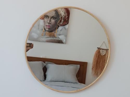a mirror over a bed with a picture of a woman at Blue Aura Beach villa Larnaca in Pervolia