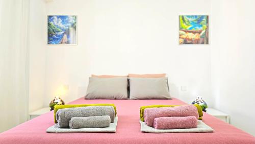 a bedroom with a pink bed with two pillows on it at CSS Coastal Smart Superior With Gym Spacious Apt in Paphos City