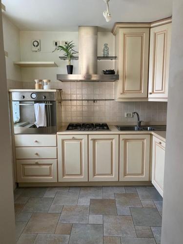 a kitchen with white cabinets and a stove at Casa degli Angeli in Varallo