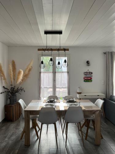 une salle à manger avec une table et des chaises en bois dans l'établissement Charmante maison de Gros-Jonc, au Bois-Plage-en-Ré