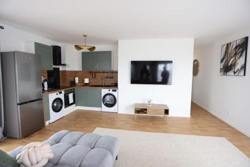 un salon avec un canapé et une cuisine dans l'établissement Apartment 10 min from Disney, à Bussy-Saint-Georges