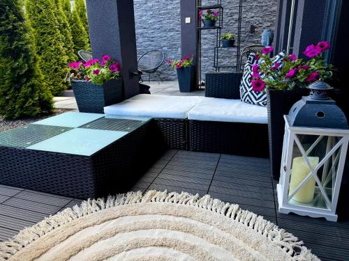 a porch with a bench and flowers on it at Vila GARUFA Wellness & Spa in Vysoké Tatry