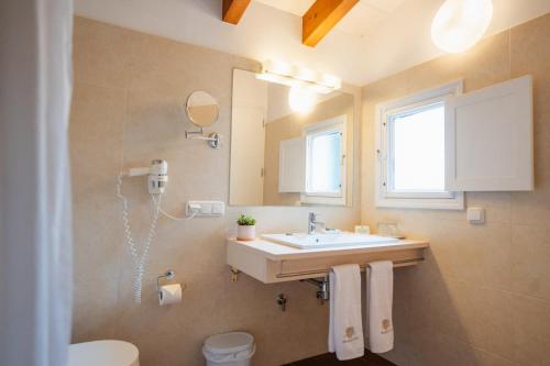 a bathroom with a sink and a mirror at Hotel Rural Binigaus Vell in Es Migjorn Gran