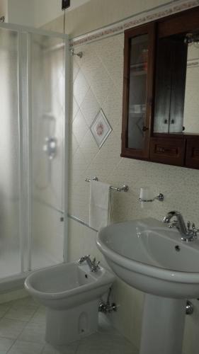 a white bathroom with a sink and a shower at B&B TENUTA BIANCA in Oliveto Citra