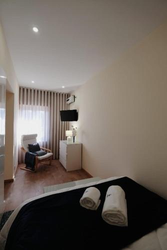 a bedroom with a bed and a living room at Casa do Fontanario em Viana do Castelo in Viana do Castelo