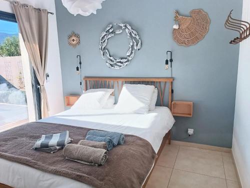 une chambre avec un lit avec deux oreillers dessus dans l'établissement Villa Posidonie, 5 pers, clim et piscine chauffée, à Lecci