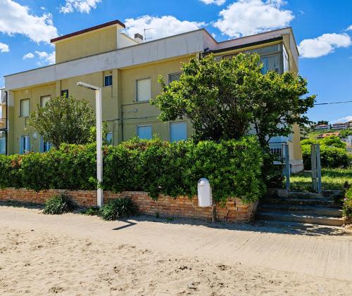 a building on the beach with bushes and a street light at Aqua Apartments in Francavilla al Mare