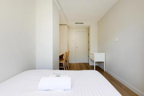 une chambre blanche avec un lit et un bureau dans l'établissement CROISETTE MARTINEZ - Luxueux T3 70m2 et balcon, à Cannes