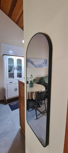 a mirror in a room with a table and a kitchen at Casa aconchego perto da praia in Guaratuba