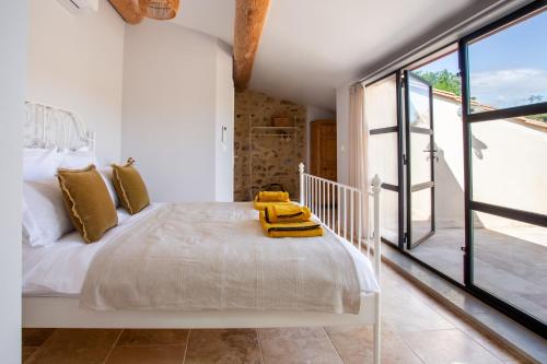 a bedroom with a white bed and a large window at Chic Converted Stables in Laurens